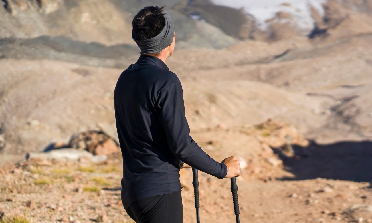 Hiker wearing merino wool apparel enjoying the benefits of merino wool for hiking on a mountainous trail