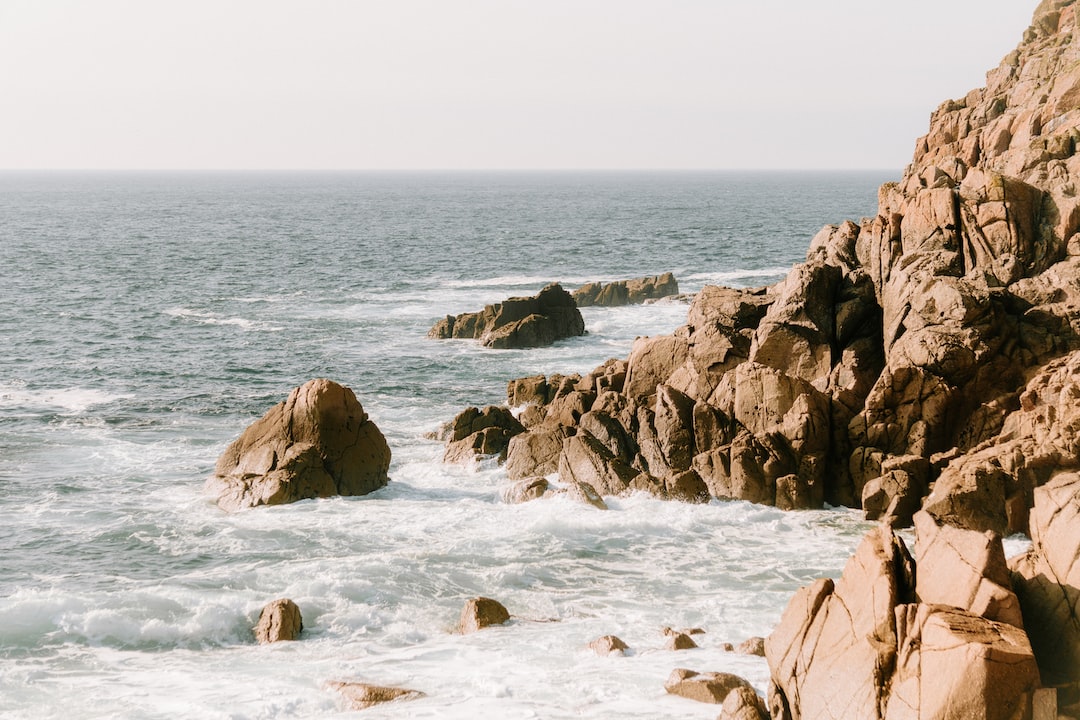 Rocky coastline with waves crashing, illustrating how to stay warm in cold weather outdoors