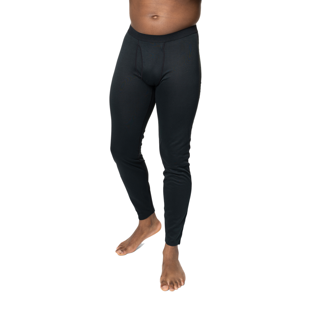 Polarmax black base layer pants for men modeled on a standing man with bare feet against black background