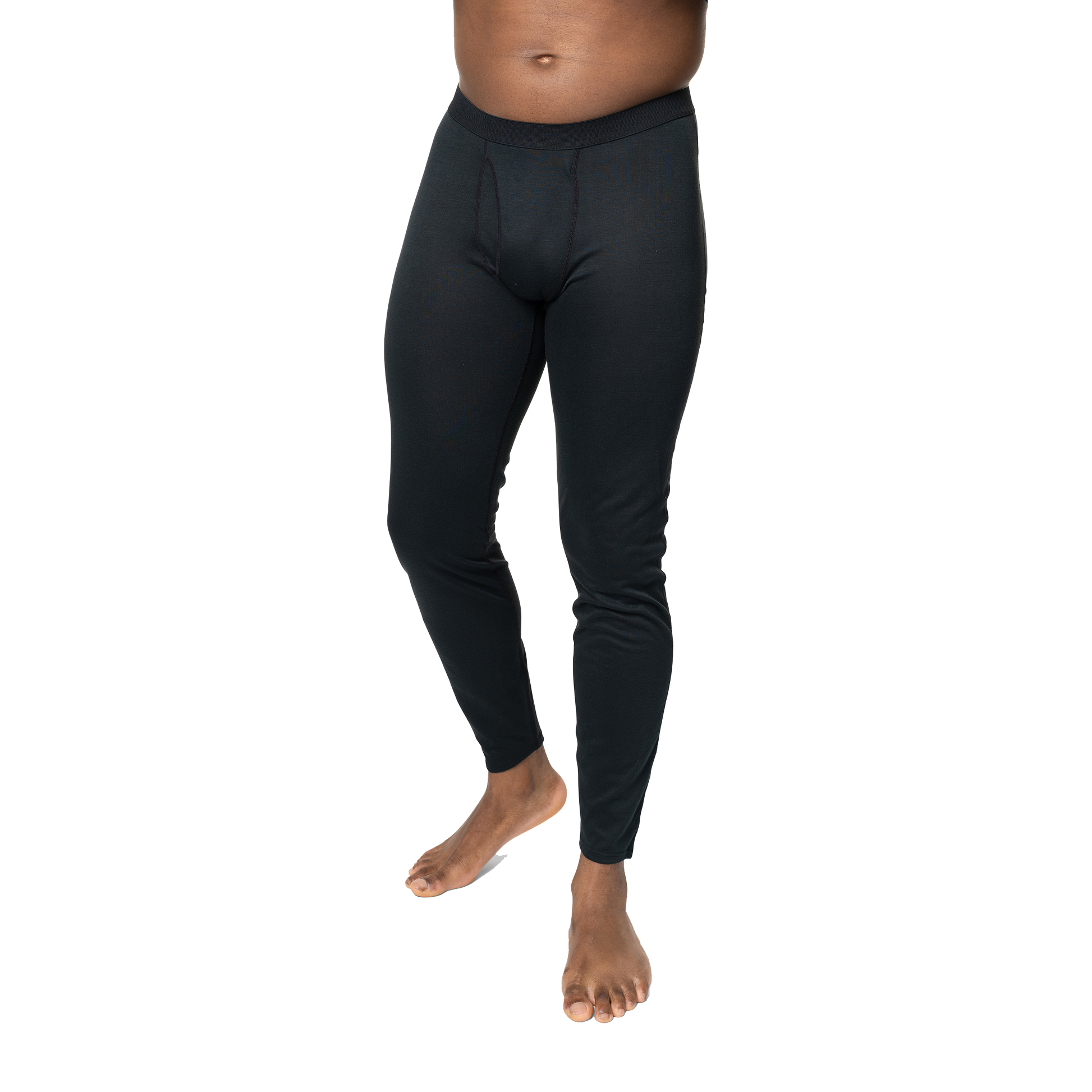 Polarmax black base layer pants for men modeled on a standing man with bare feet against black background