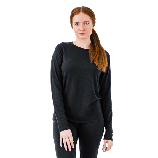 Model wearing a lightweight merino wool top in black, perfect for cold weather as a base layer for warmth and comfort